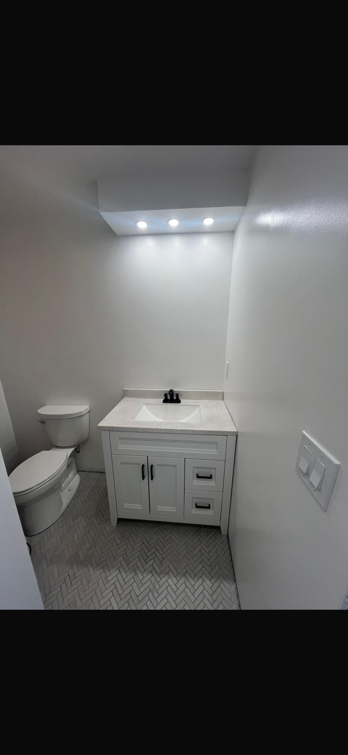 Garage-to-ADU bath with vanity and herringbone tile