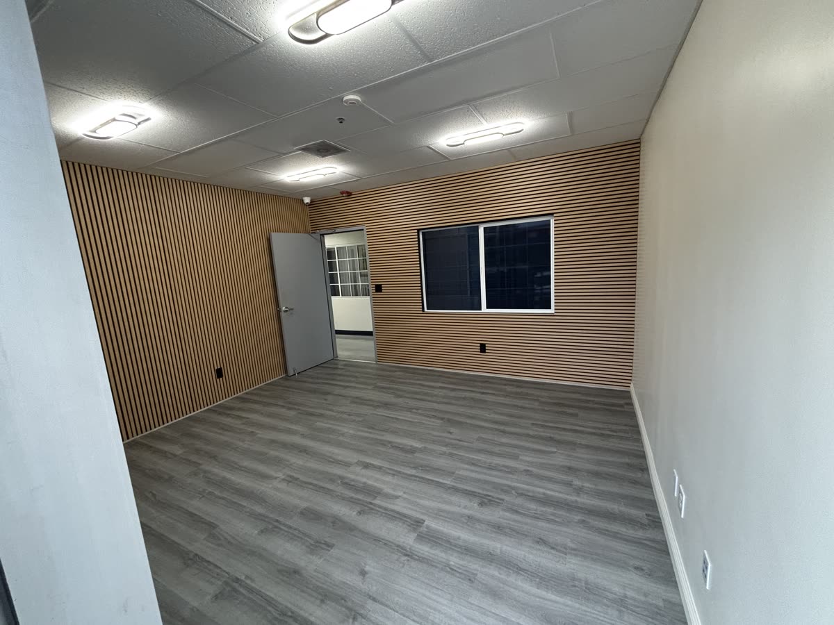 Office remodel with wood slat feature walls and flooring